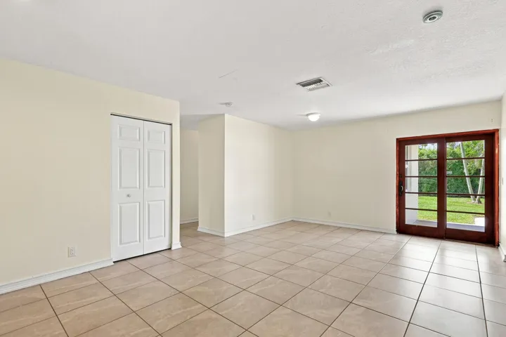 Bright, open living space with tile flooring and French doors providing natural light.
