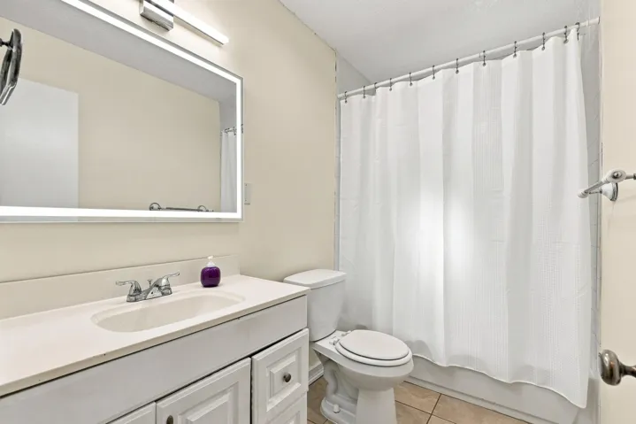 Full bathroom with vanity, tub and shower combination, and neutral finishes.