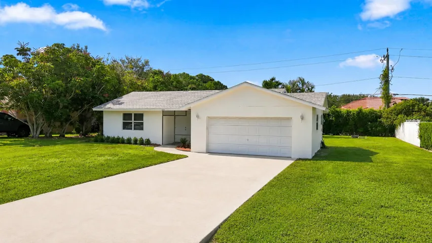 Alternate exterior view showing the driveway, front yard, and home entrance.