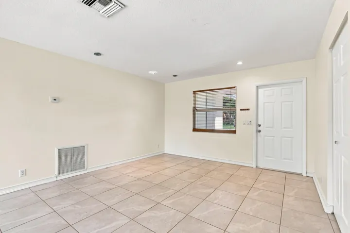 Tiled living space with neutral finishes, recessed lighting, and natural light.