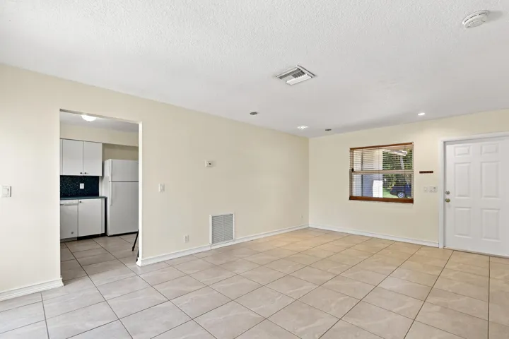 Open living area with tile flooring and convenient access to the kitchen.