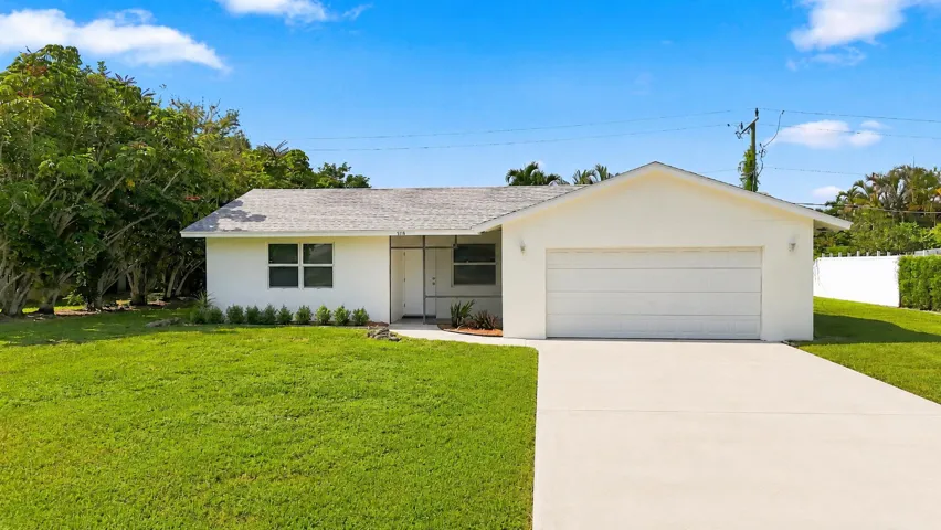 Front view of the home with attached garage, driveway, and lawn.