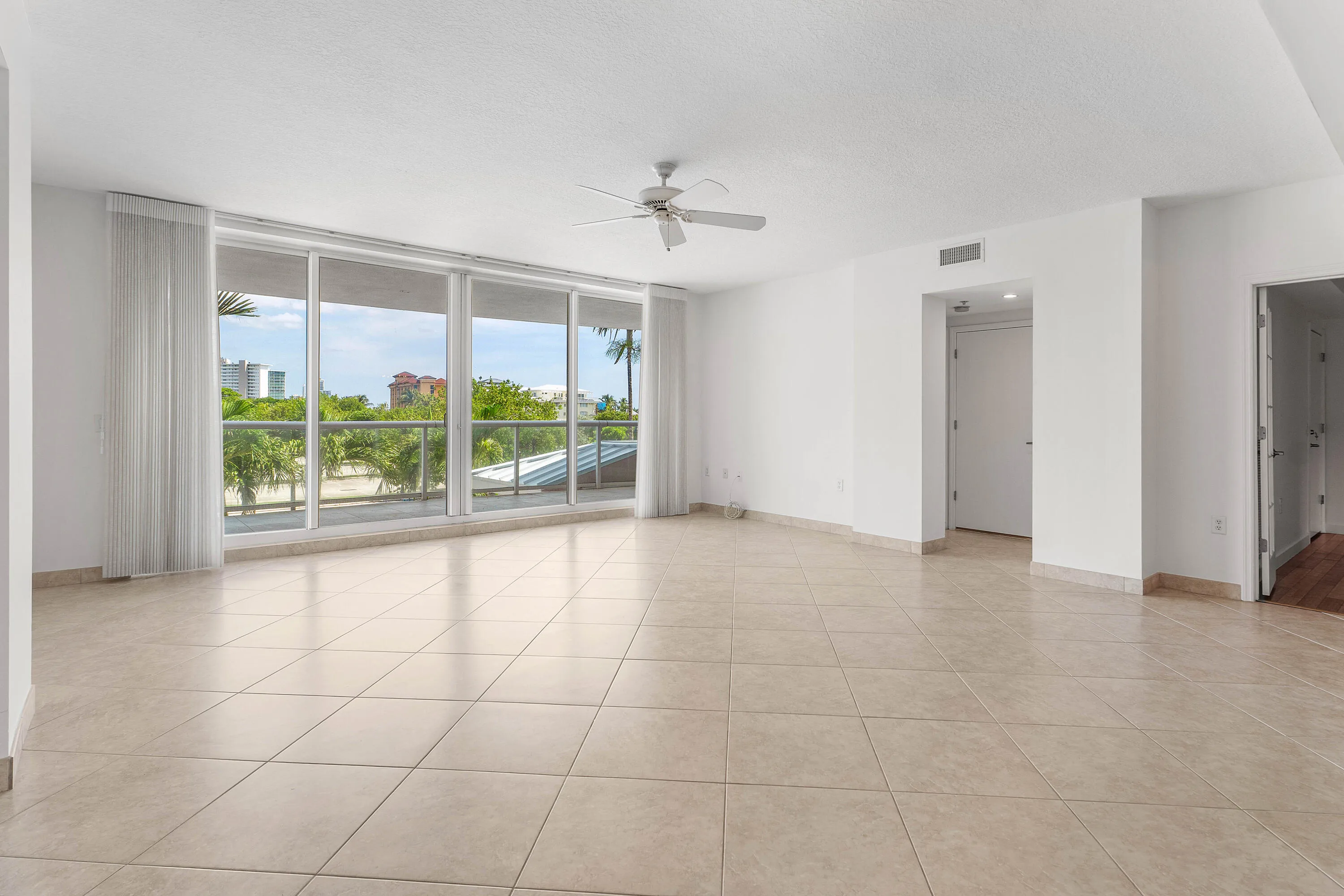 Expansive floor-to-ceiling windows, neutral ceramic tile flooring.