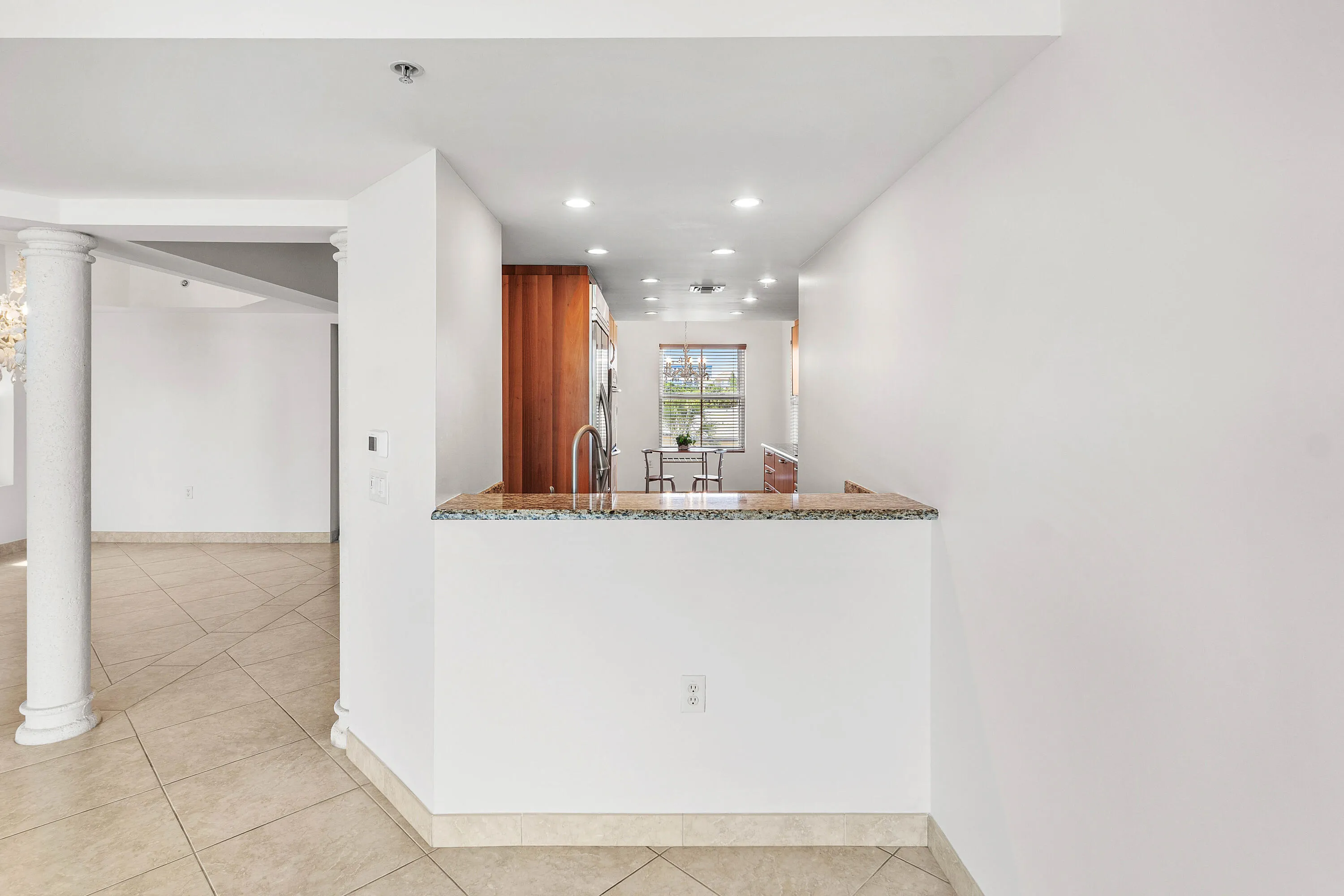 Kitchen with wood-finish cabinetry, stainless steel sink, and recessed lighting