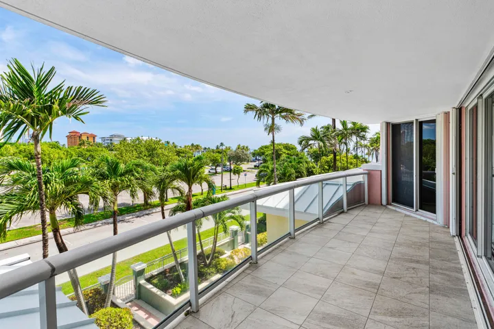 Expansive balcony featuring tile flooring and a glass railing