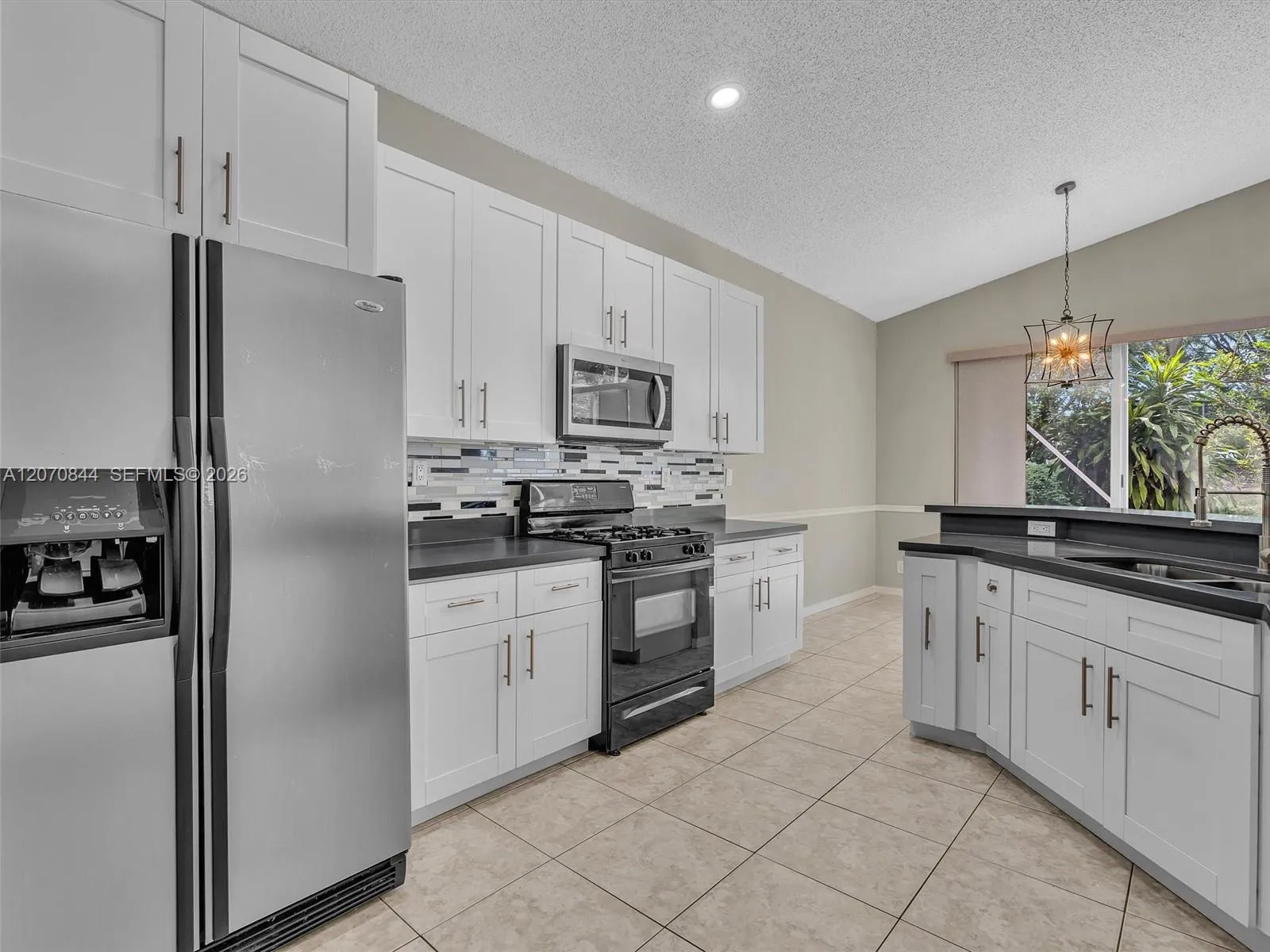 Well-designed kitchen offering an easy, functional flow with plenty of cabinetry, soft close cabinets, quartz countertops, and a convenient pantry with a door.