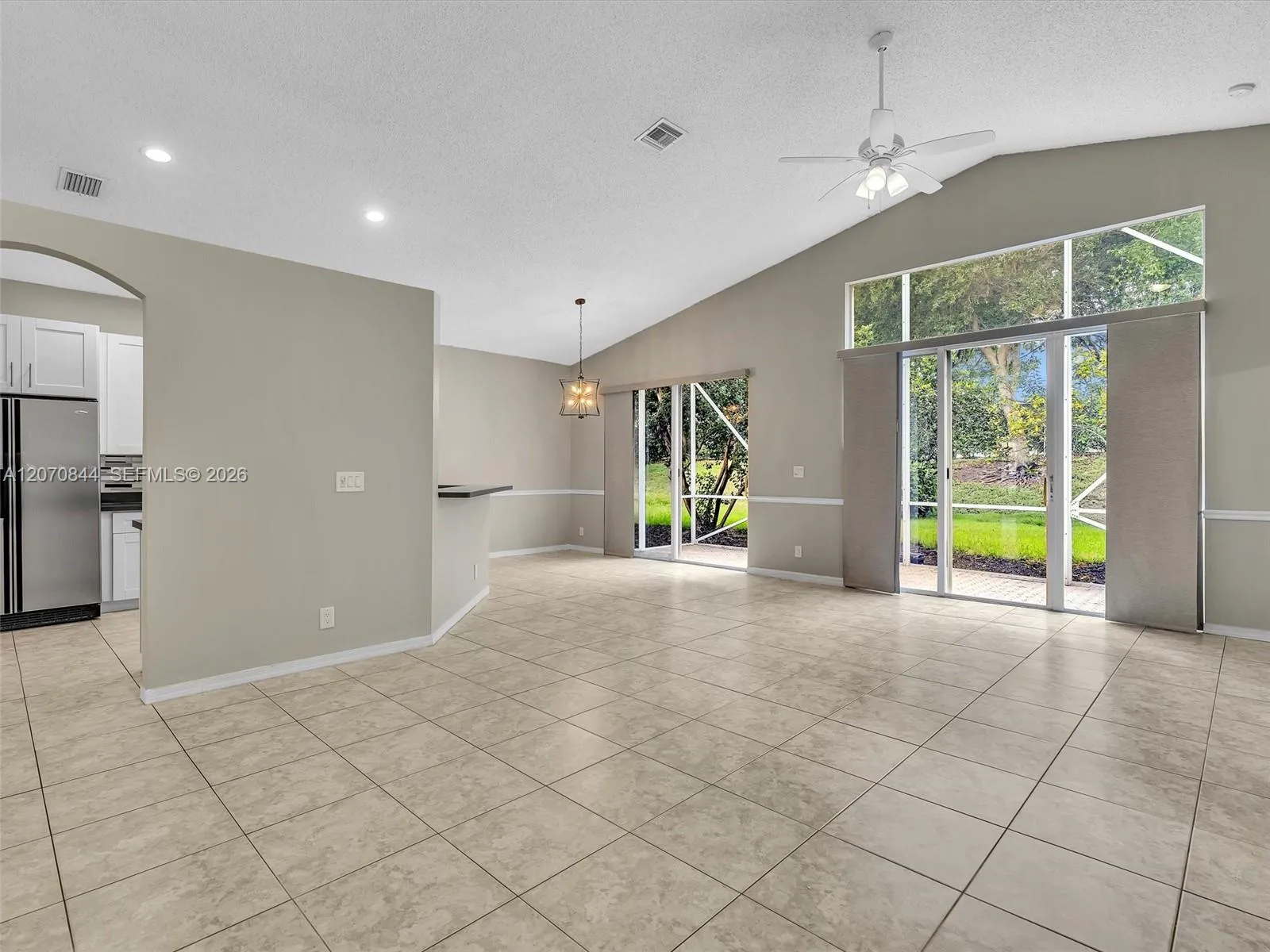 Spacious living room featuring soaring vaulted ceiling, creating an open, airy atmosphere filled with natural light.