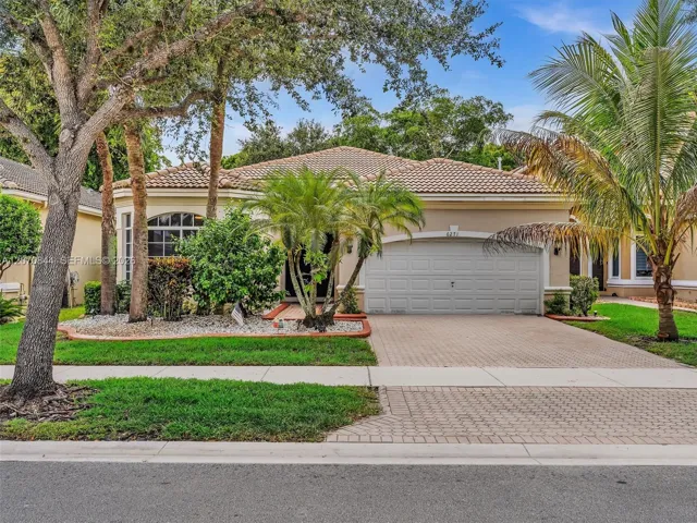 Inviting curb appeal with a beautifully maintained front landscape and a spacious driveway offering additional parking.