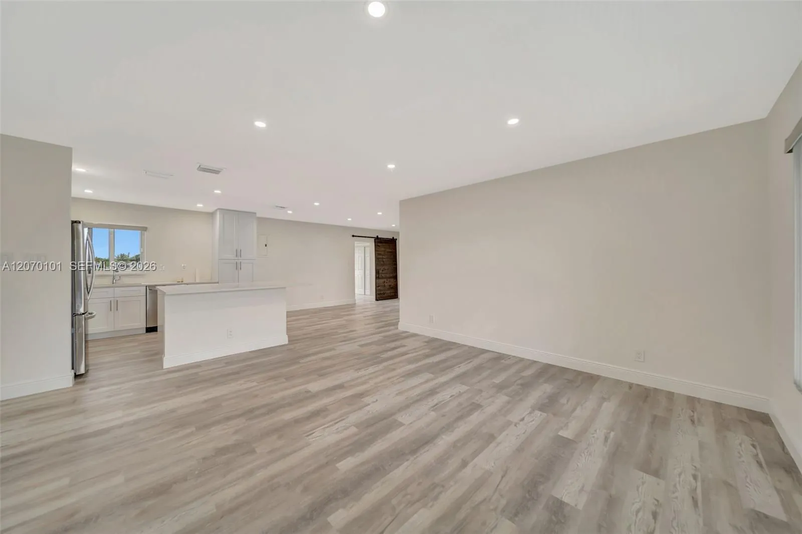 Wide shot toward kitchen, barn door visible