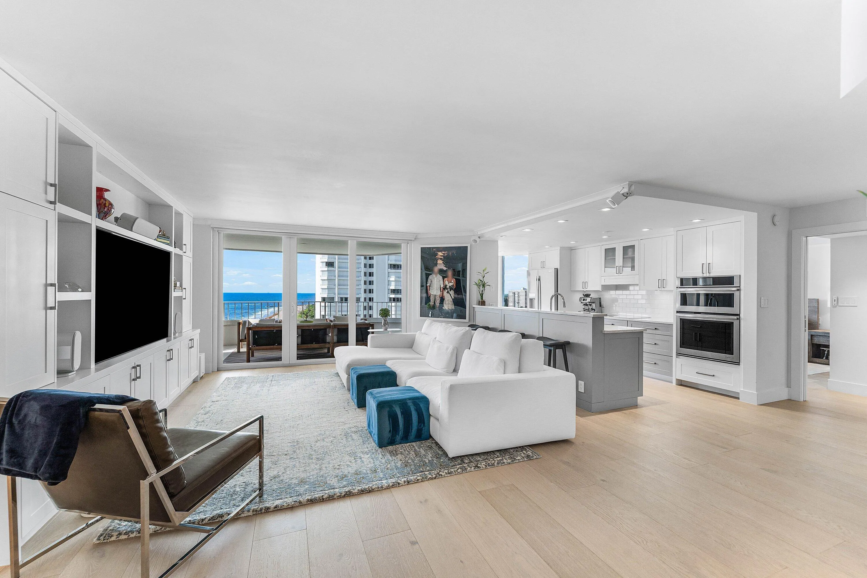 Open-concept living area with wood-finish flooring, built-in cabinetry, and a kitchen featuring a peninsula with seating