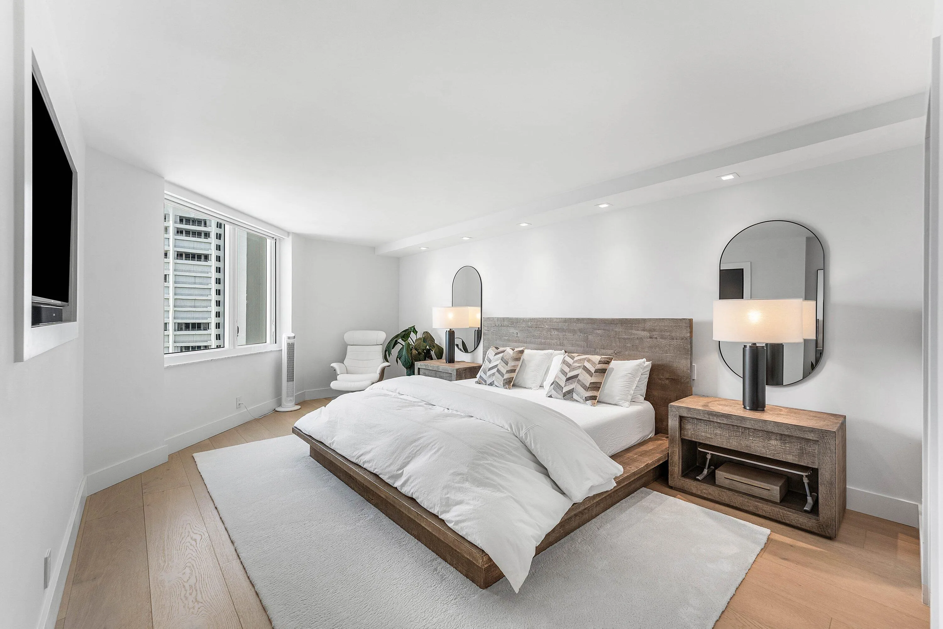 Hardwood-style flooring, recessed lighting, and a large window with city architecture