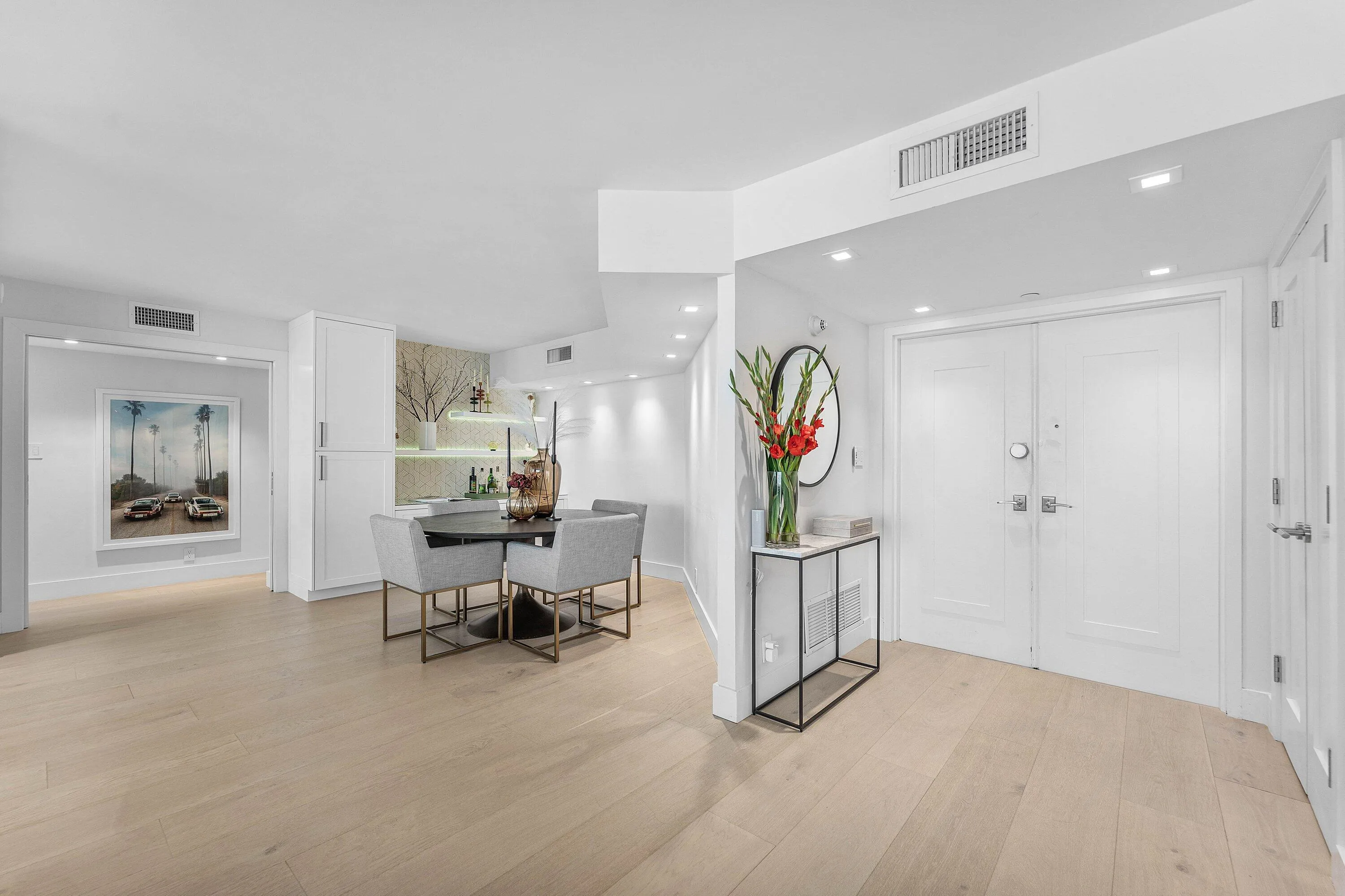 Light wood-finish flooring throughout, featuring a double-door entry