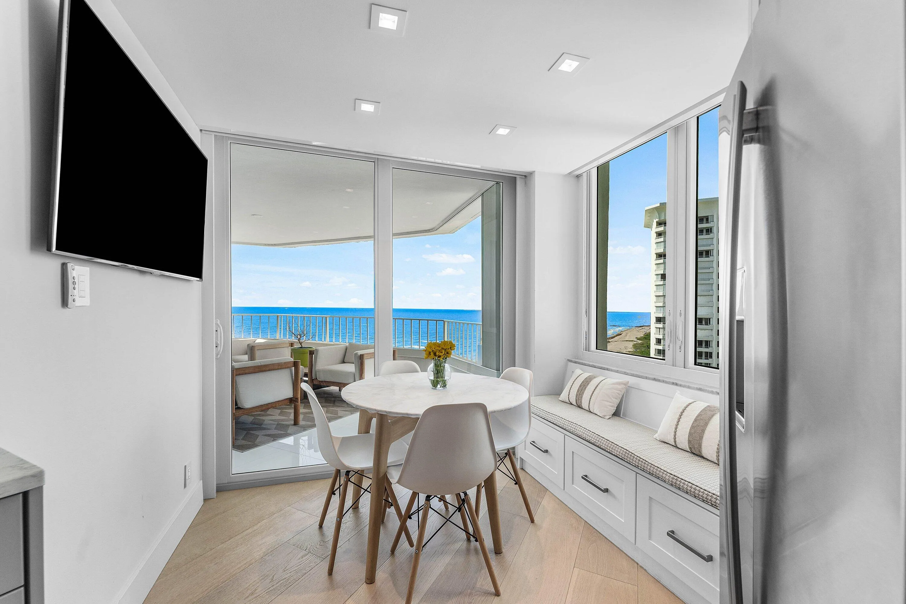 Wood-finish flooring, recessed lighting, built-in window seating with storage, and stainless steel refrigerator