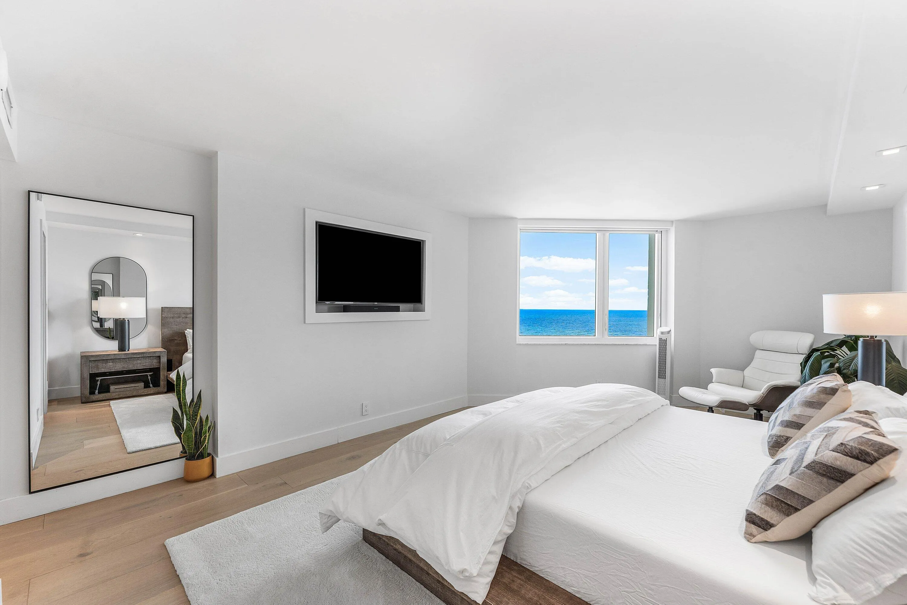 Integrated wall-mounted television, recessed lighting, and wood-finish flooring