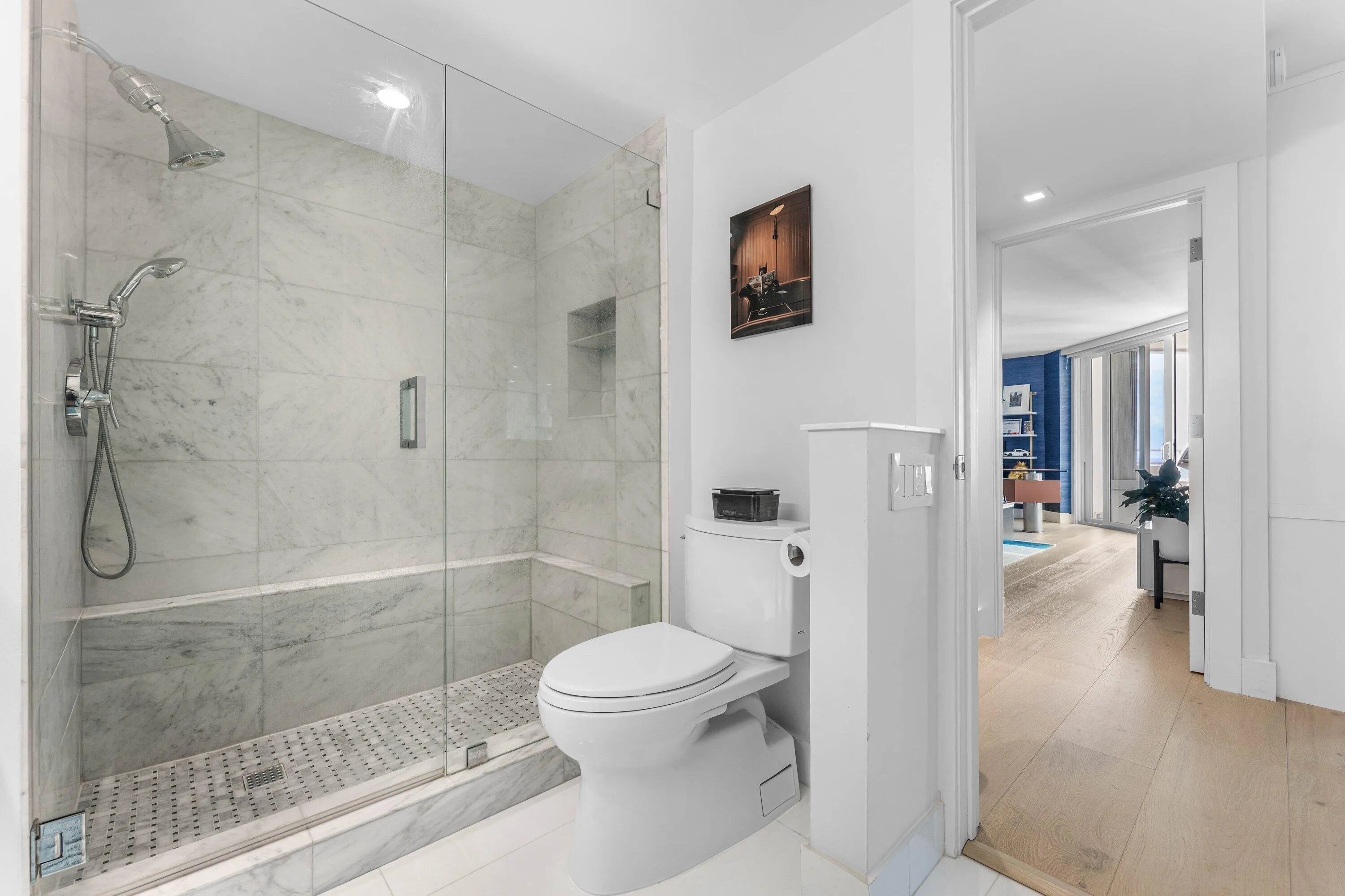 Glass-enclosed shower with a built-in bench, recessed shower niche, and ceiling-mounted rain showerhead
