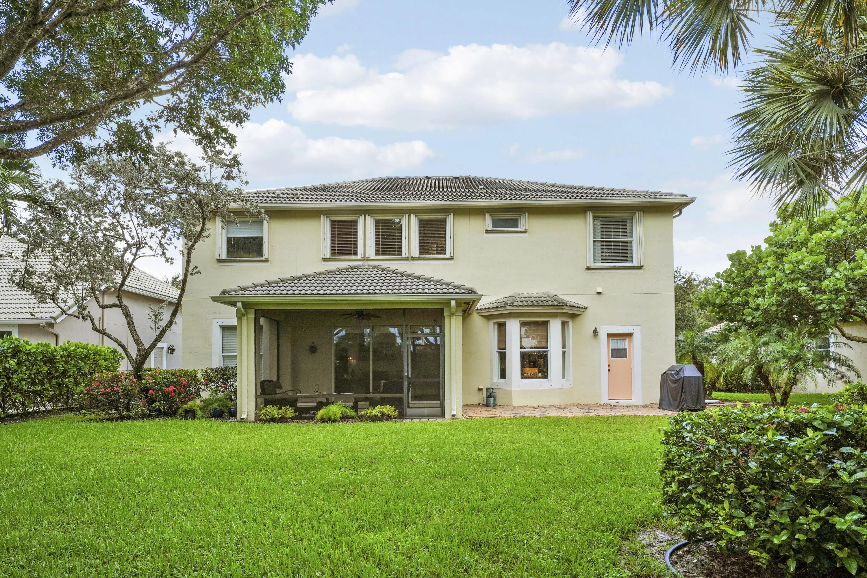 Rear exterior featuring a screened patio and additional open patio space