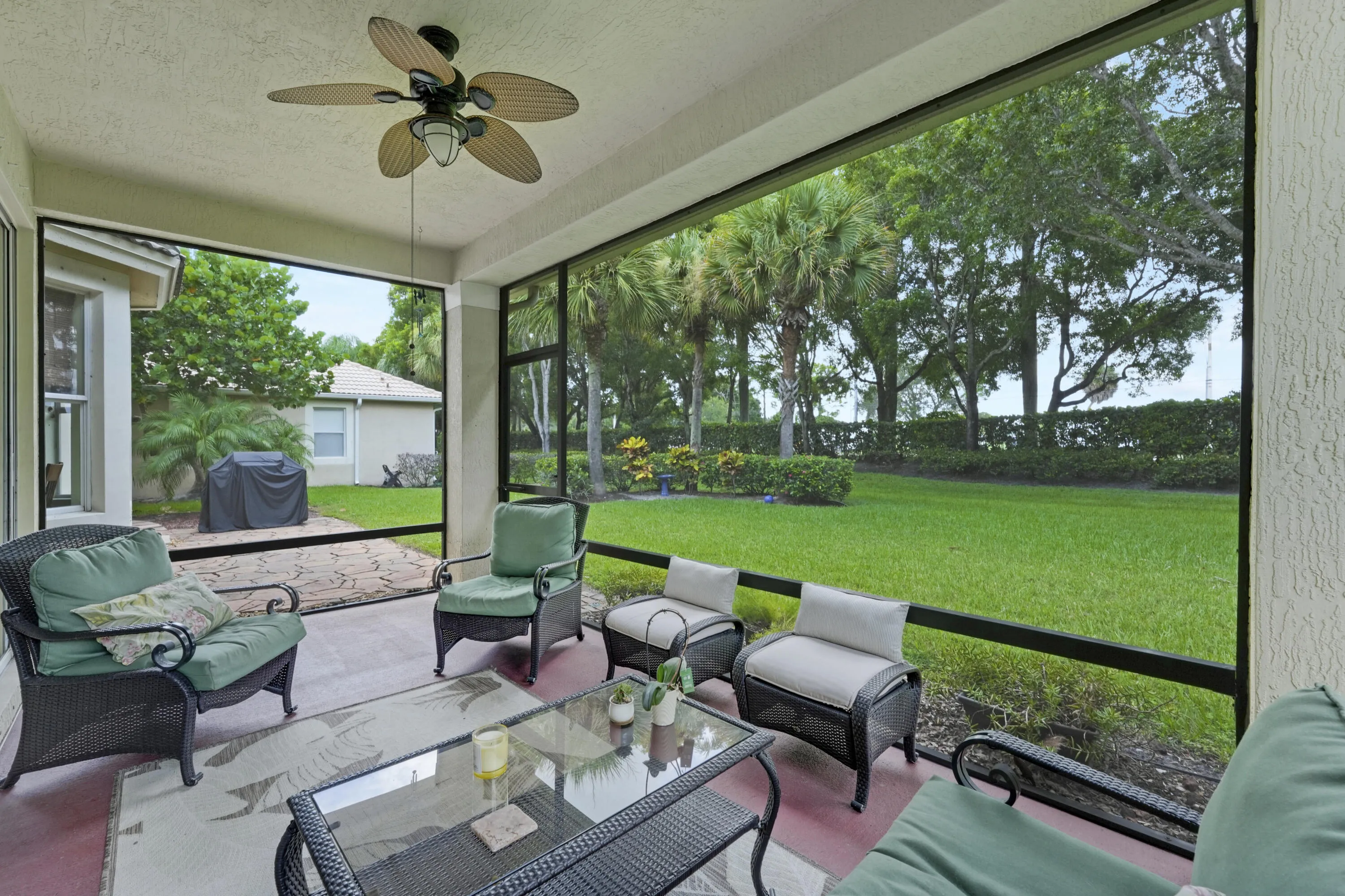 Screened outdoor living area overlooking the expansive backyard