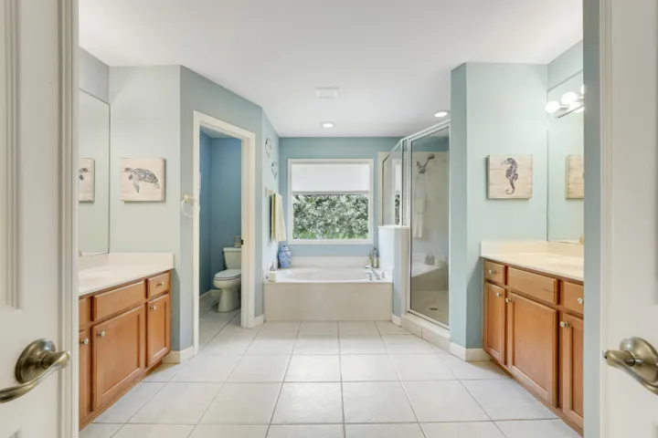 Spacious primary bathroom with dual vanities, soaking tub and separate shower
