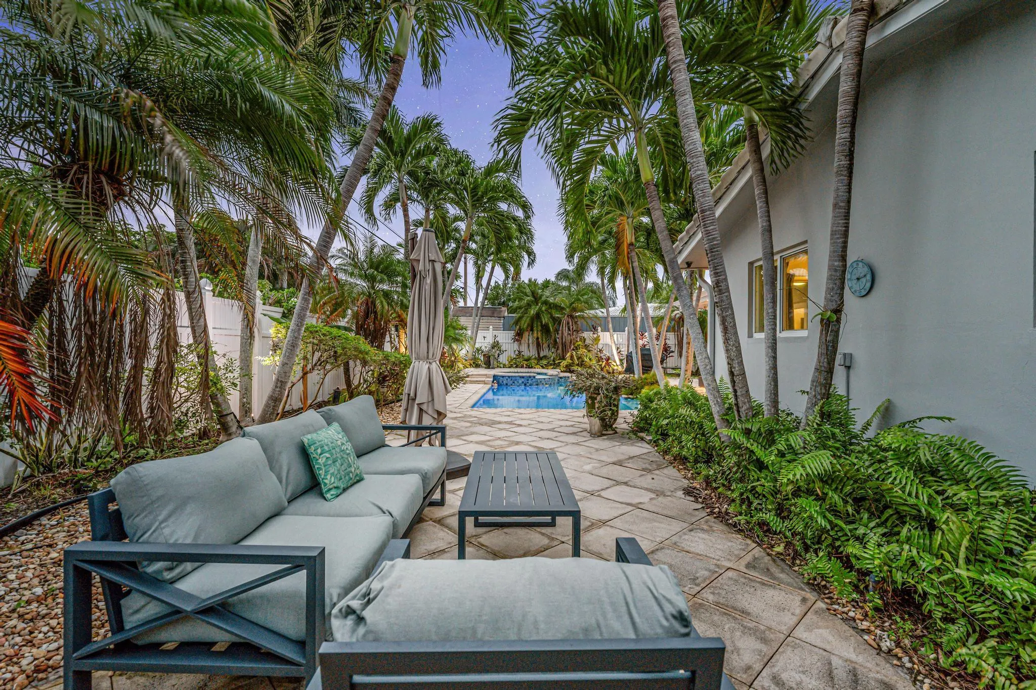 Secluded private yard with multiple seating areas and view of pool