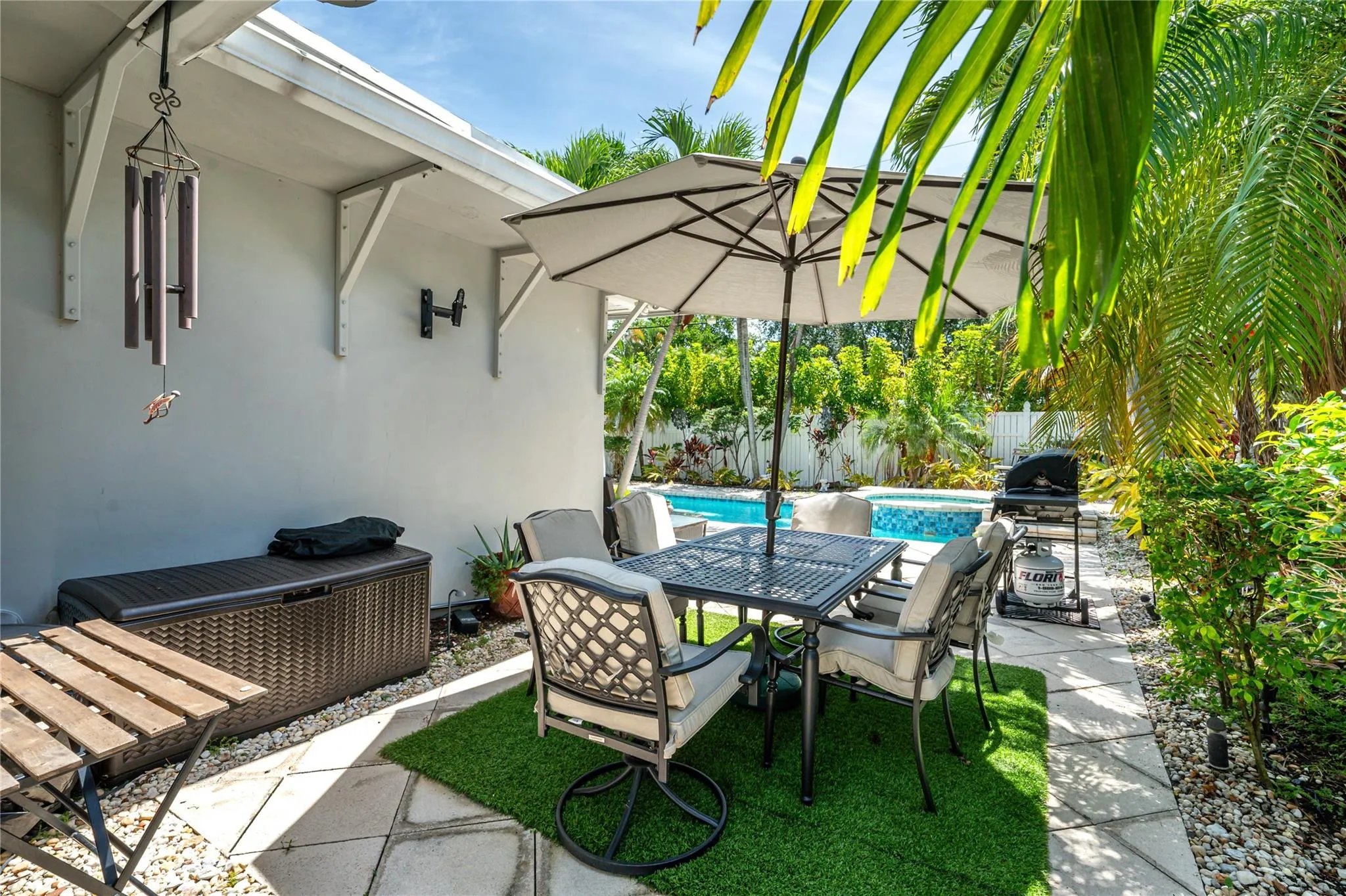 Secluded private yard with multiple seating areas and view of pool