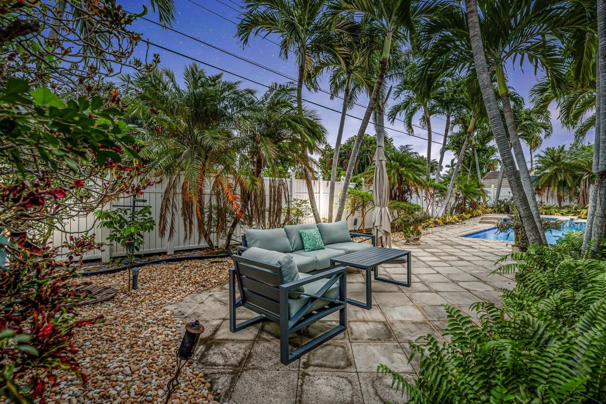Secluded private yard with multiple seating areas and view of pool