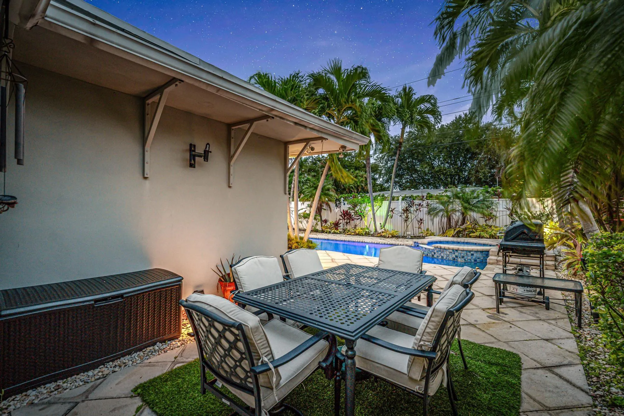Secluded private yard with multiple seating areas and view of pool