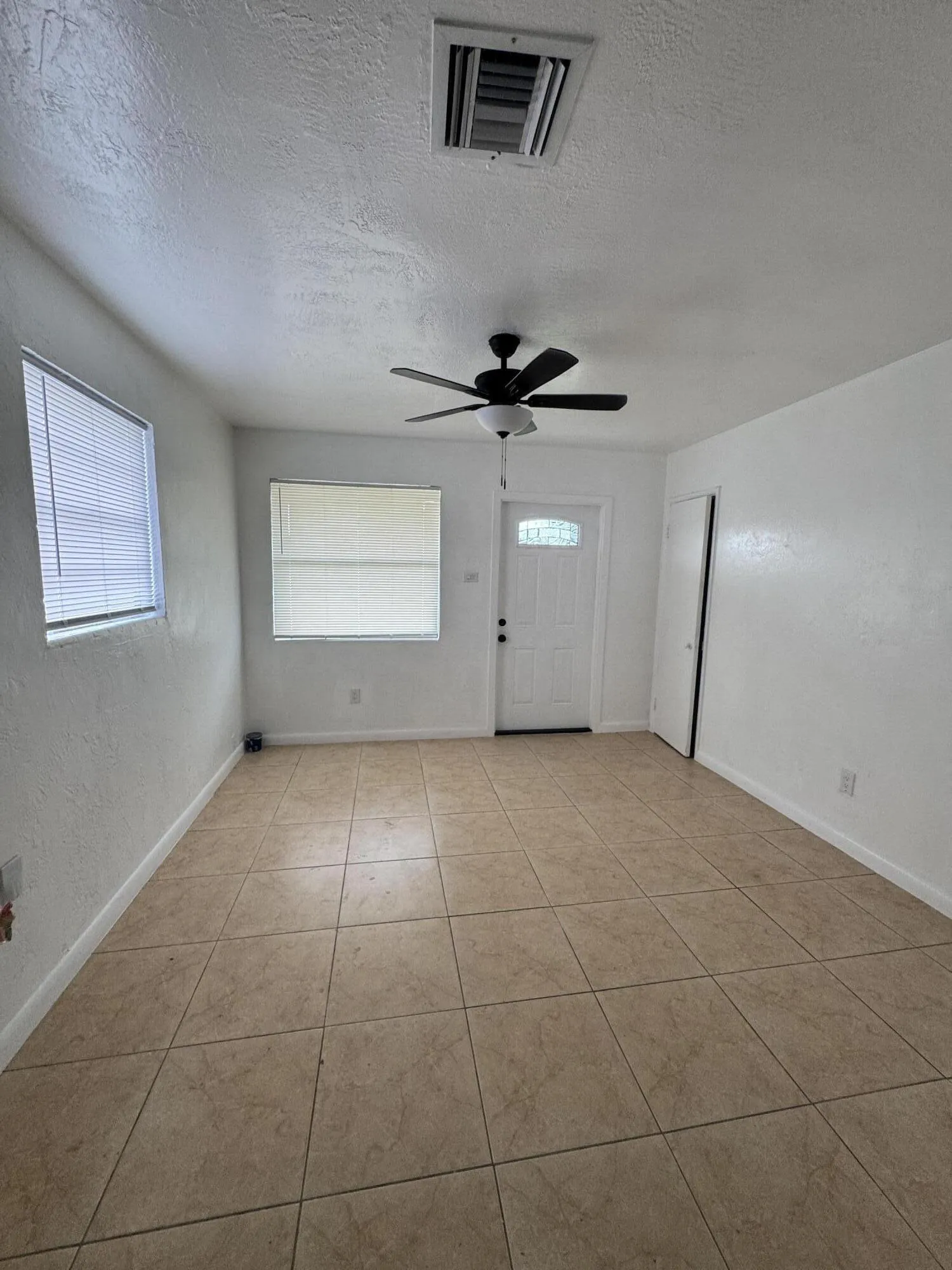 Bright living room with brand new ceiling fan and new window blinds. Affordable Fort Lauderdale single family home with no HOA and a large fenced yard.
