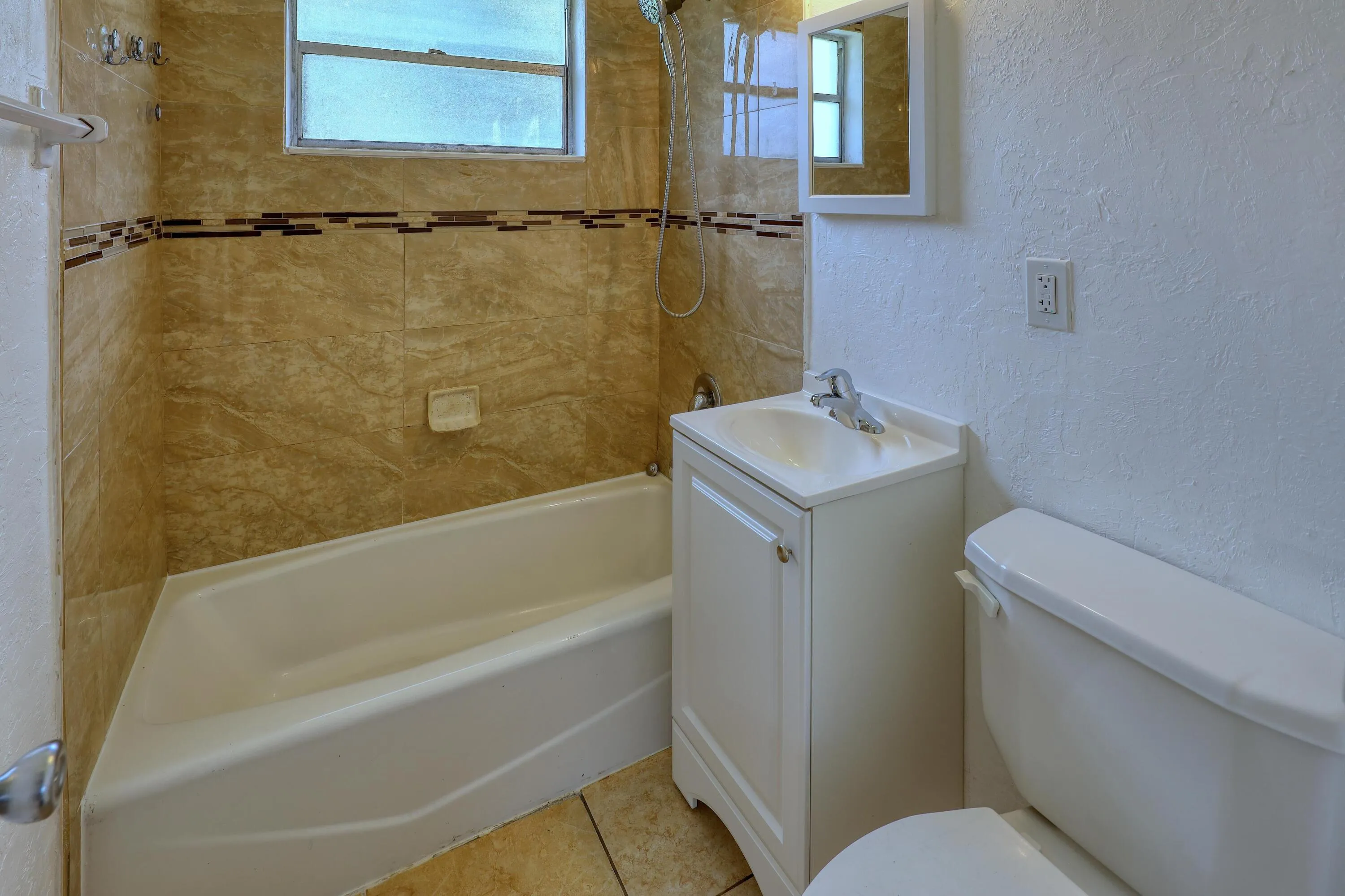 Full bathroom with tub and shower combination, tile flooring and natural light. Ready for the next owner to add their own colors and finishing touches.