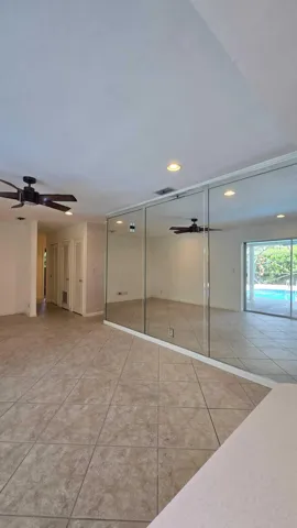 Tile flooring, mirrored wall, recessed lighting, ceiling fans, sliding glass doors