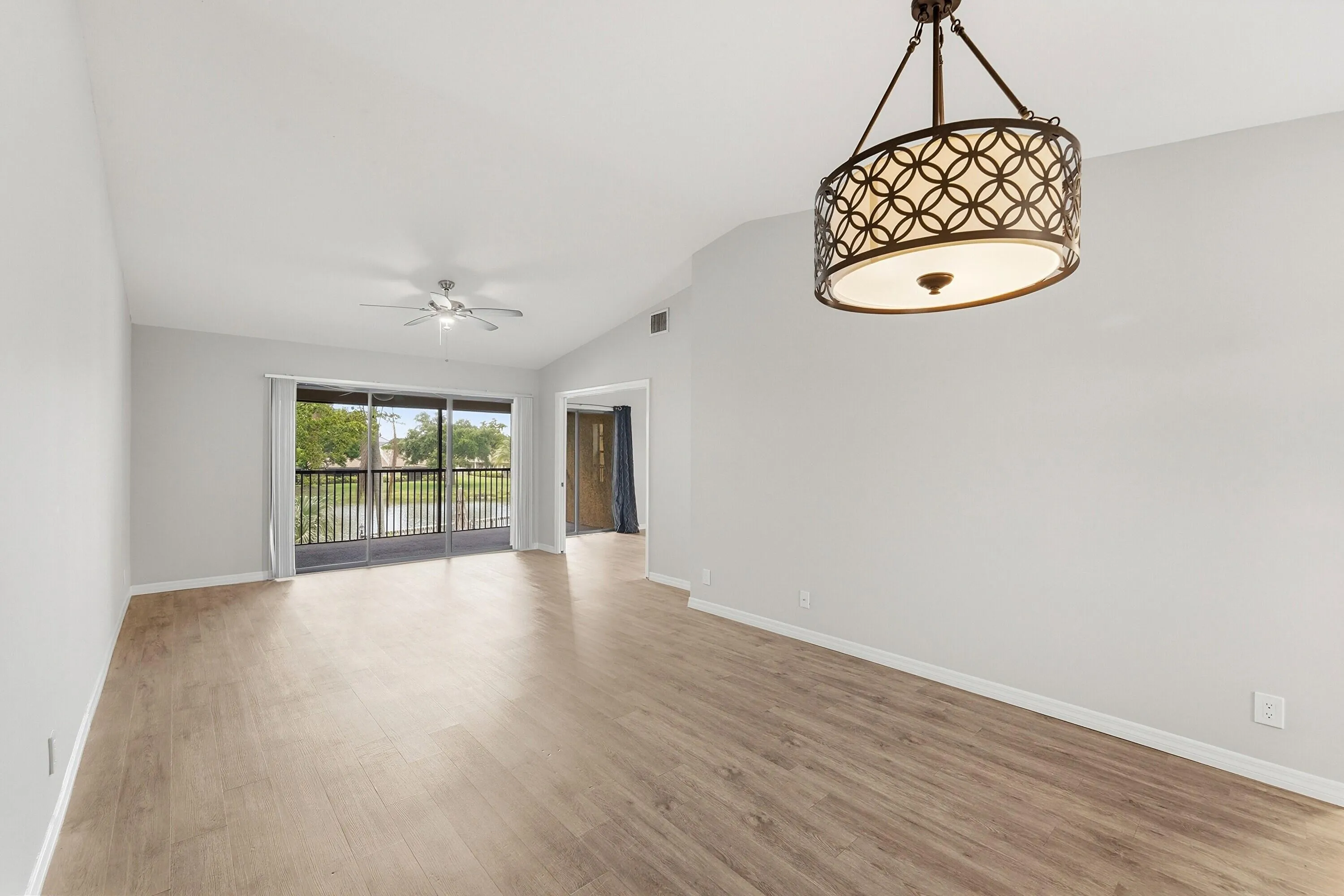 Wood-finish flooring, vaulted ceilings, and a decorative chandelier