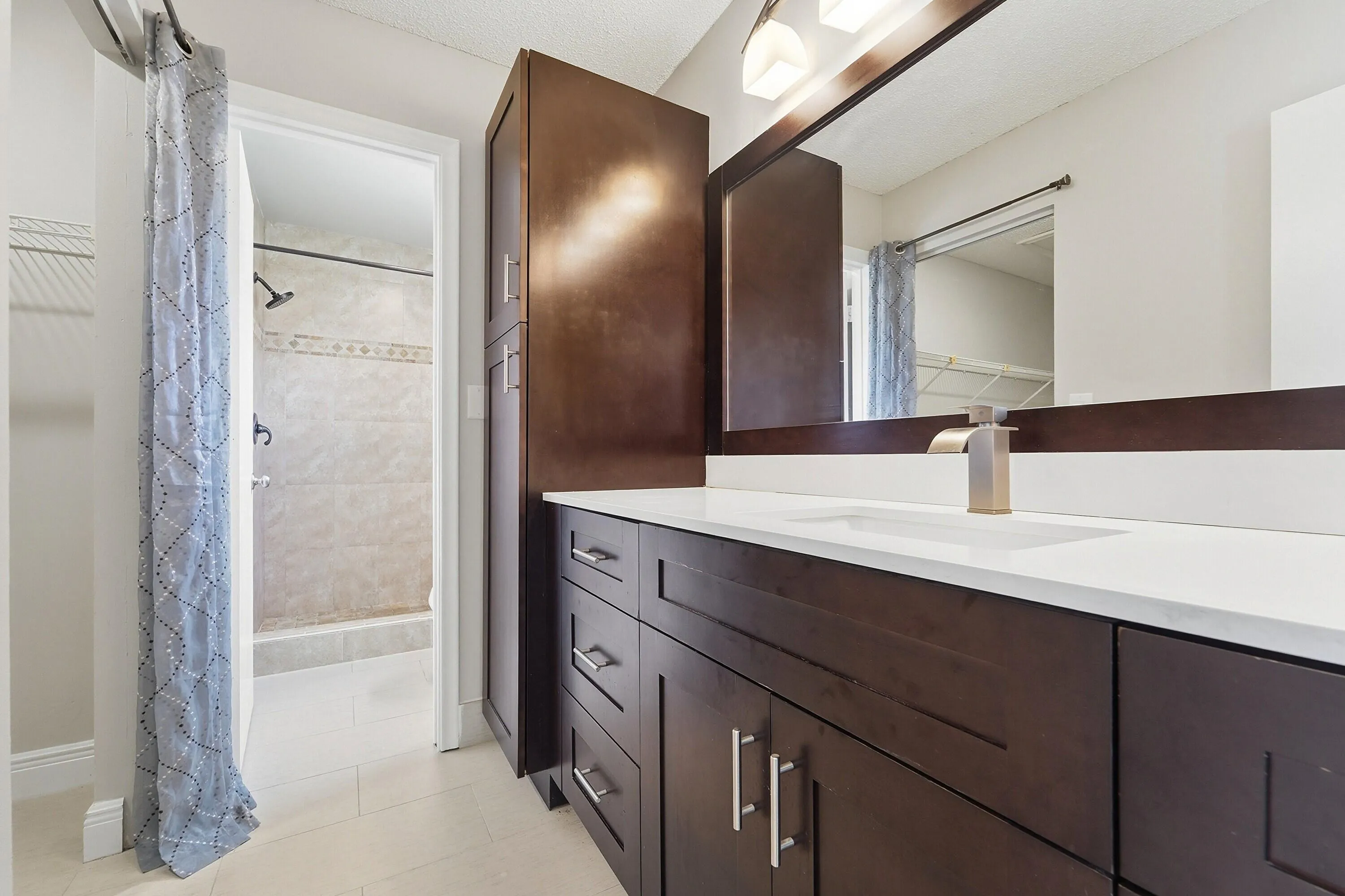 Dark wood-finish vanity with a white countertop and integrated sink