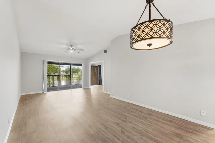 Wood-finish flooring, vaulted ceilings, and a decorative chandelier