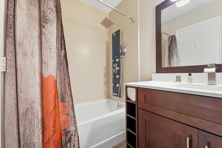 Tub and shower combination with a rainfall showerhead and body spray panel