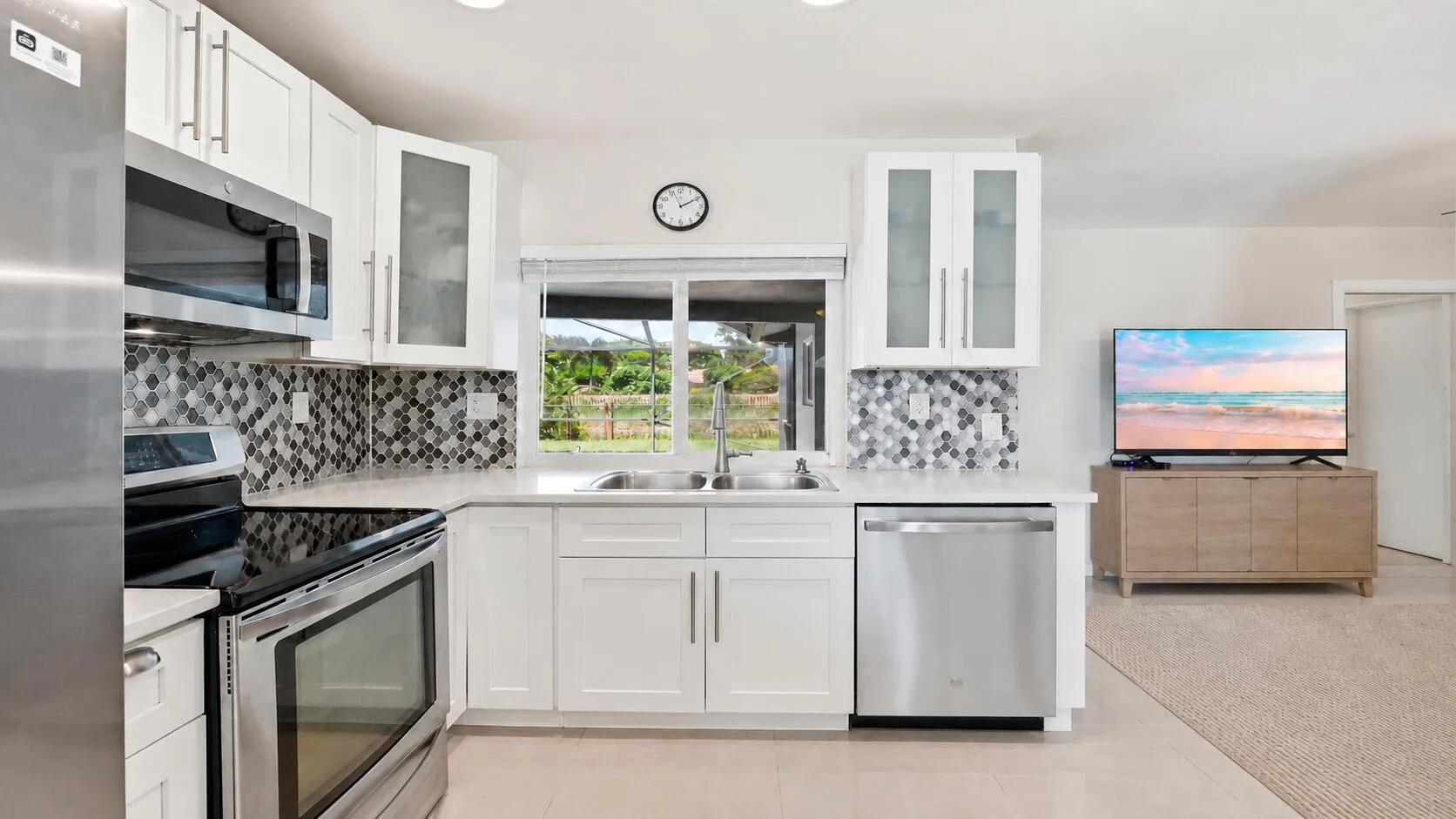 Kitchen overlooking the pool and Family Room. (virtually staged for illustrative purposes; no permanent features or finishes have been altered)