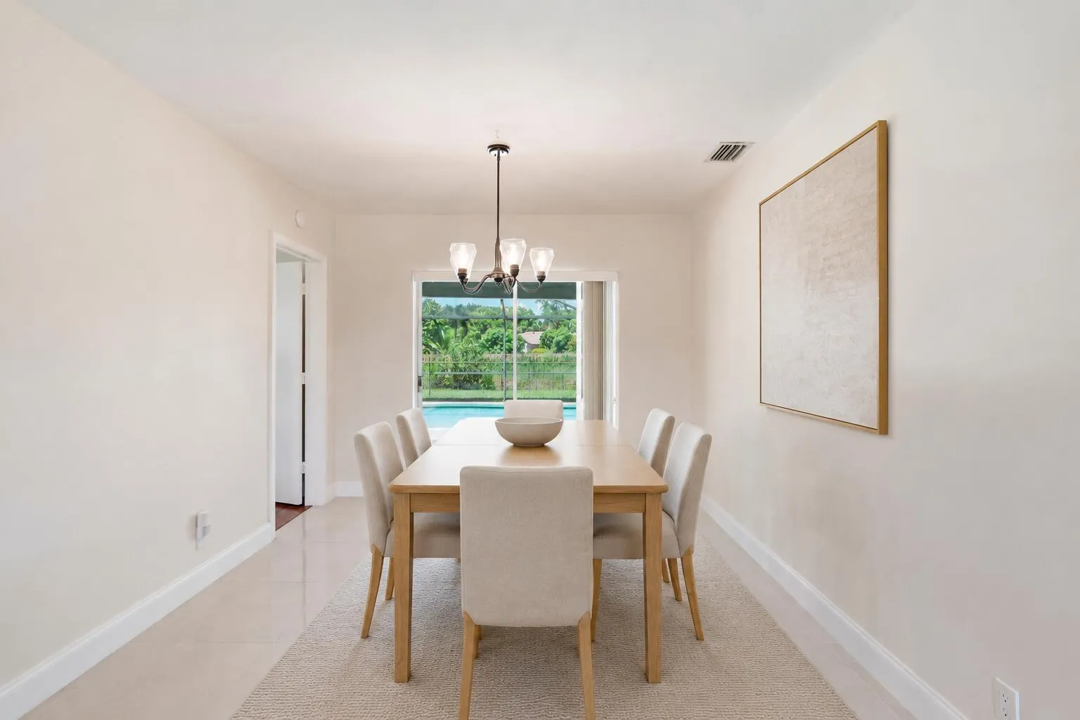 Dining Room with access to patio/pool. (virtually staged for illustrative purposes; no permanent features or finishes have been altered)