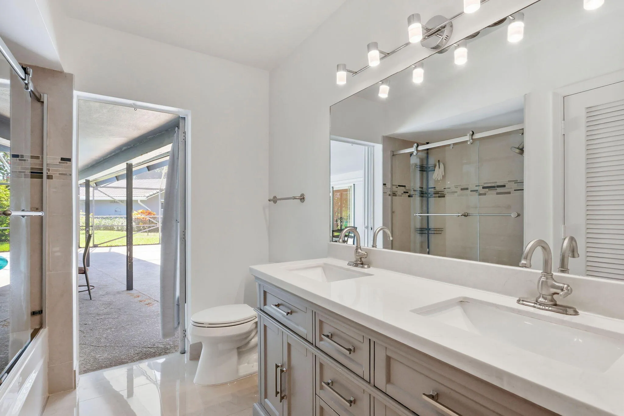 cabana bathroom leads directly to patio/pool. (virtually staged for illustrative purposes; no permanent features or finishes have been altered)