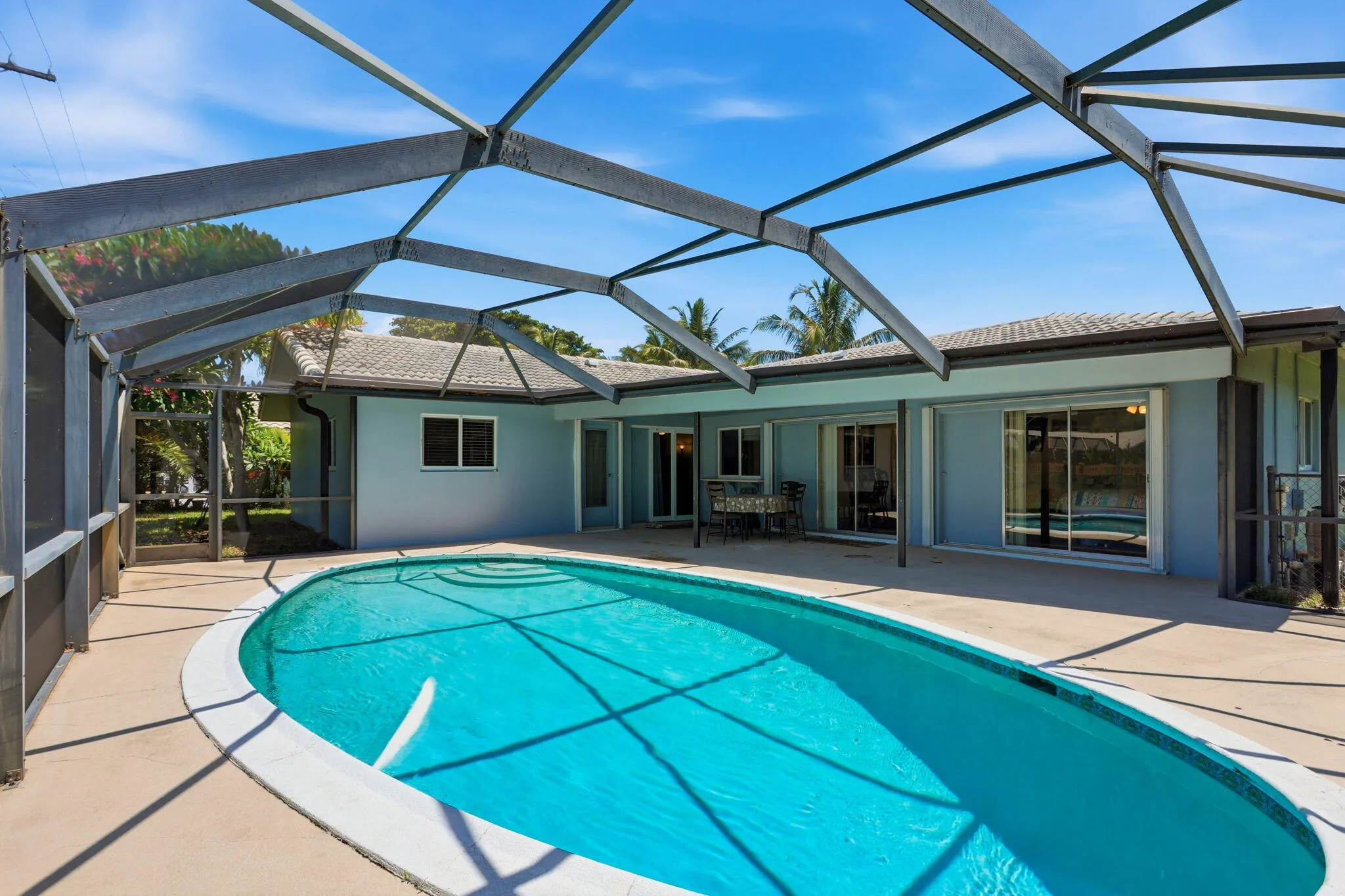 Screen enclosed patio/pool with large overhang.