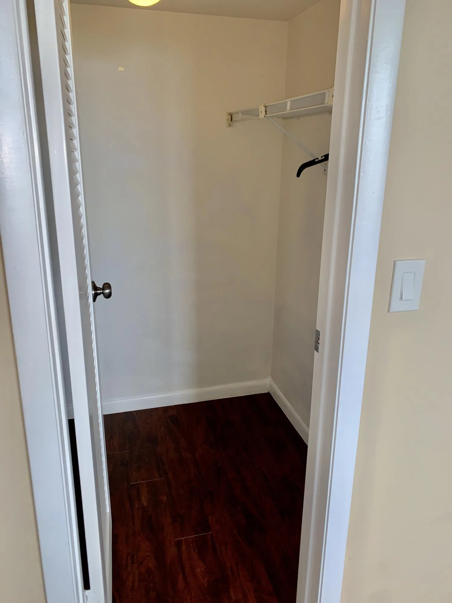 Recessed closet featuring wood-finish flooring, white baseboards, and a wire shelving system