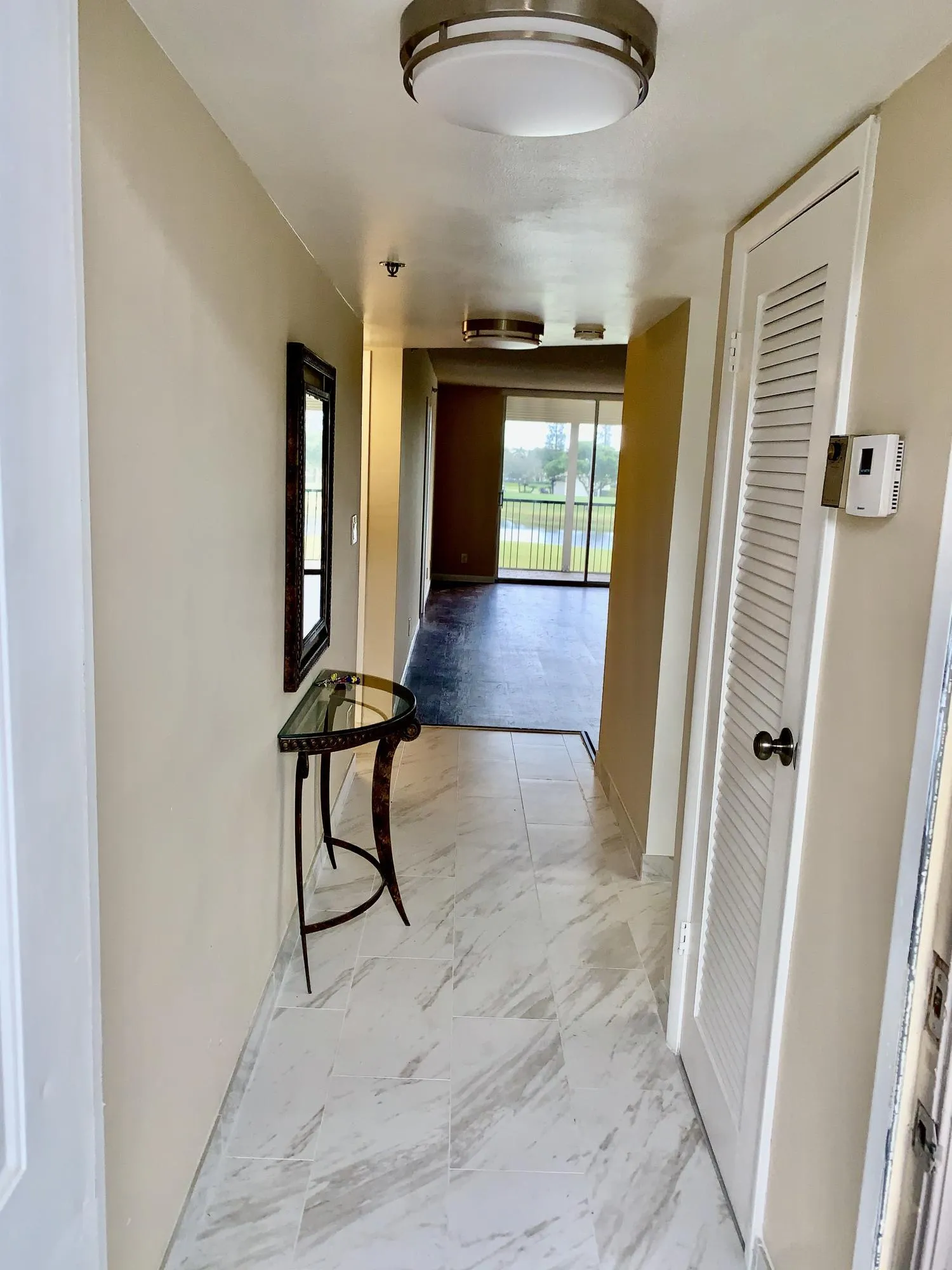 Entryway with light-toned tiled flooring, featuring a flush-mount ceiling light
