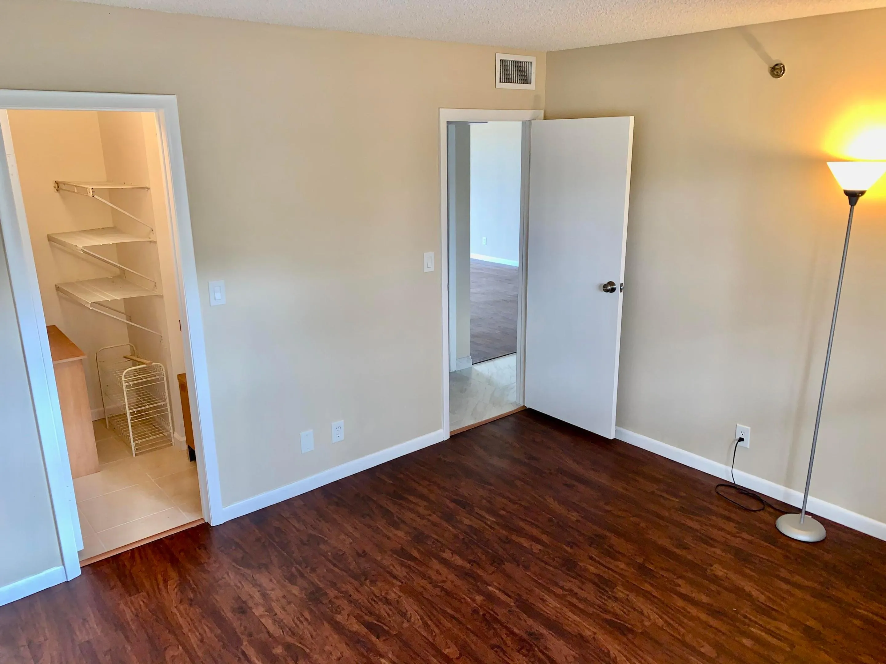 Spacious room featuring rich wood-finish flooring and neutral wall tones