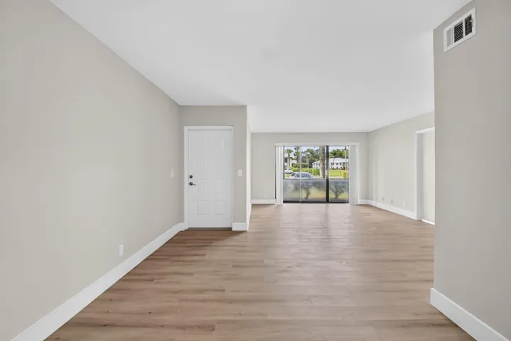 Wood-finish flooring throughout, light neutral wall paint, and white trim