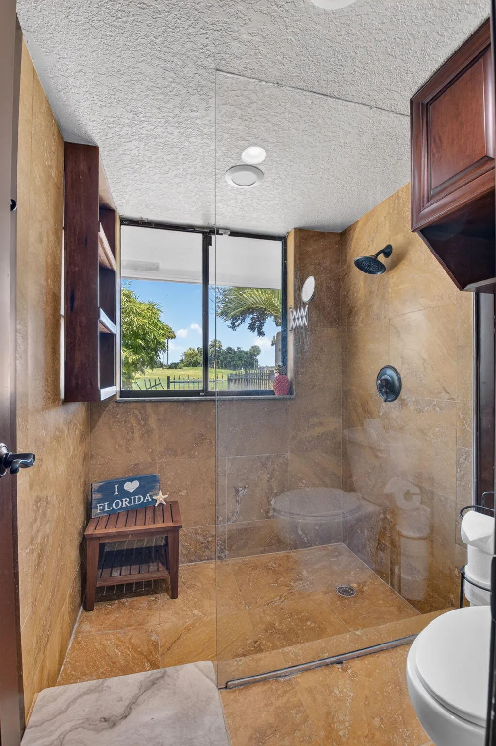 Updated primary bath with sweeping golf course view. Wash away your stress in the frameless shower tiled to the ceiling.