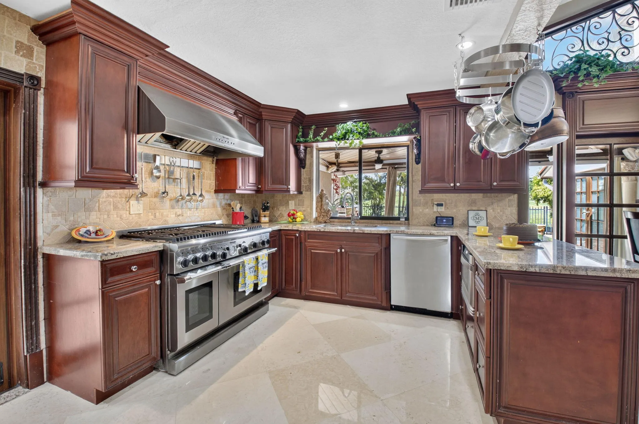 Double granite countertops adorn the rich cabinets with crown molding.