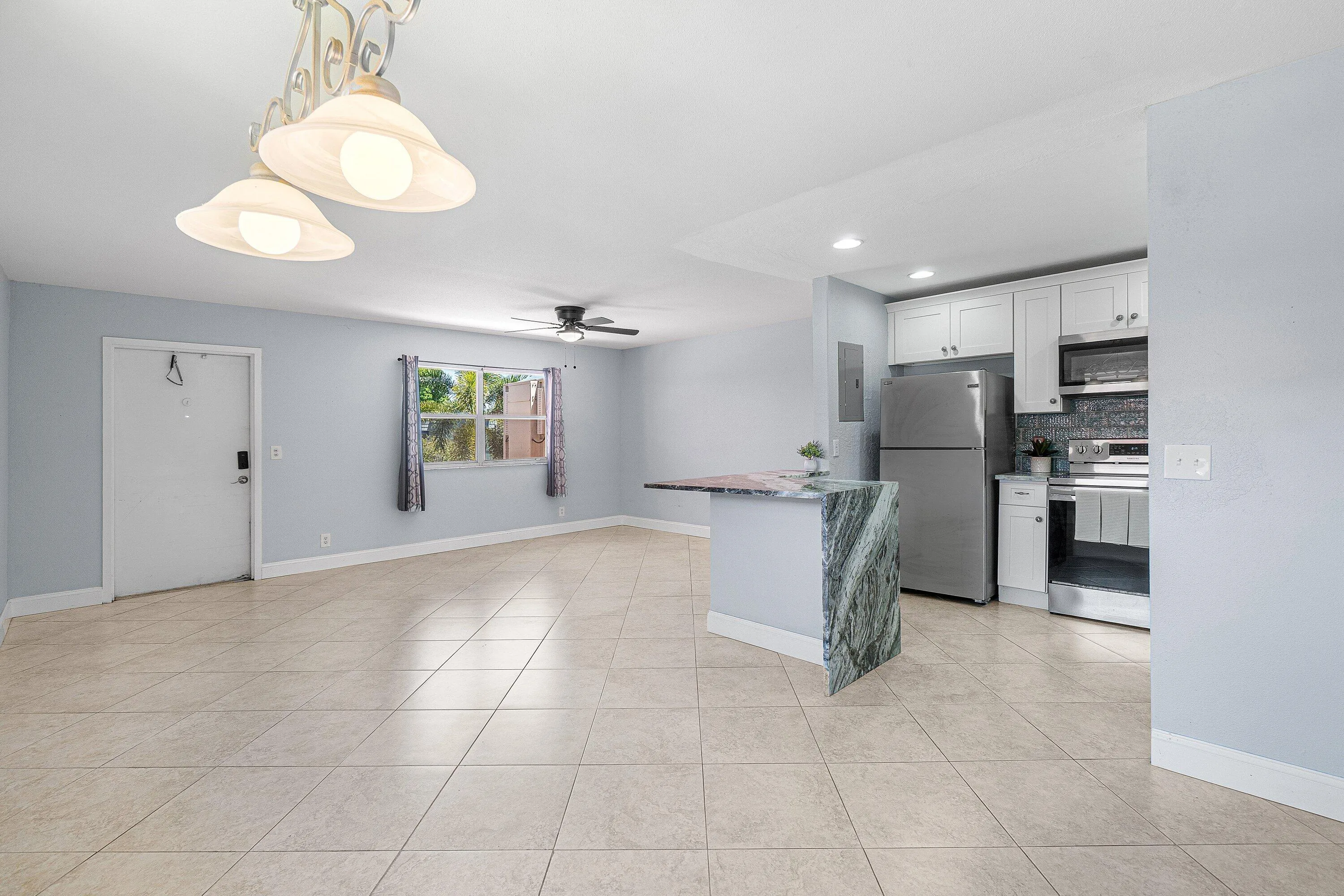 Open-concept living area with tile flooring and a ceiling fan