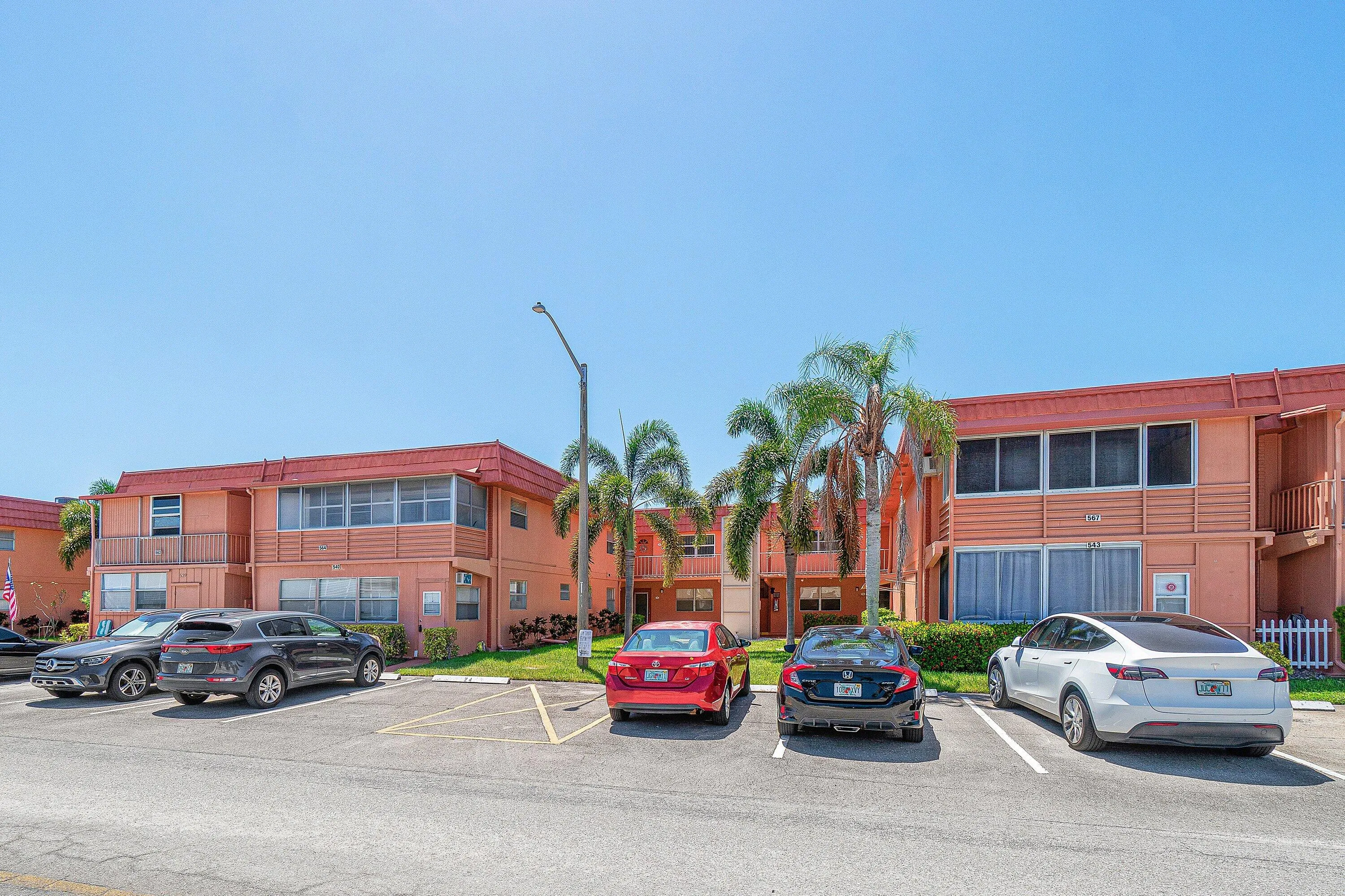 Multi-story exterior with a red tile roof and multiple screened balconies