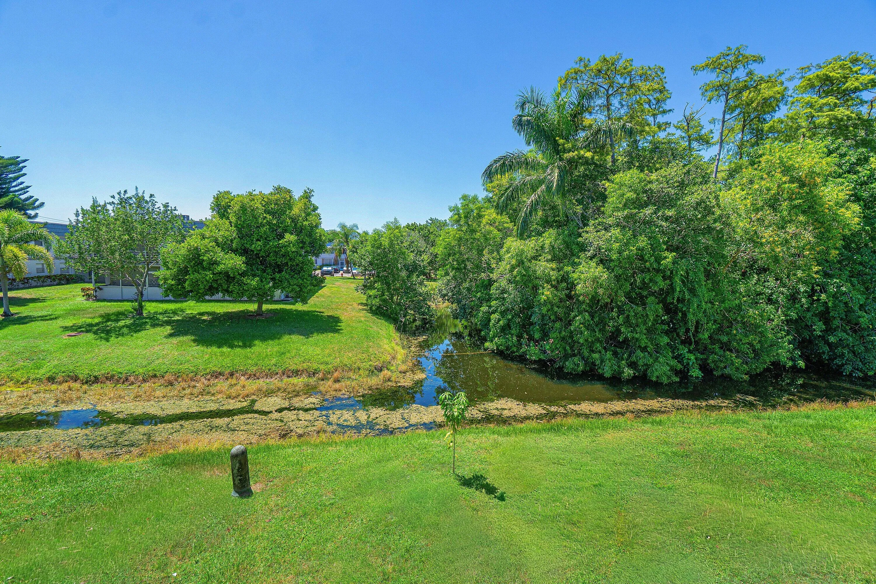 Expansive green space featuring a water canal and lush trees
