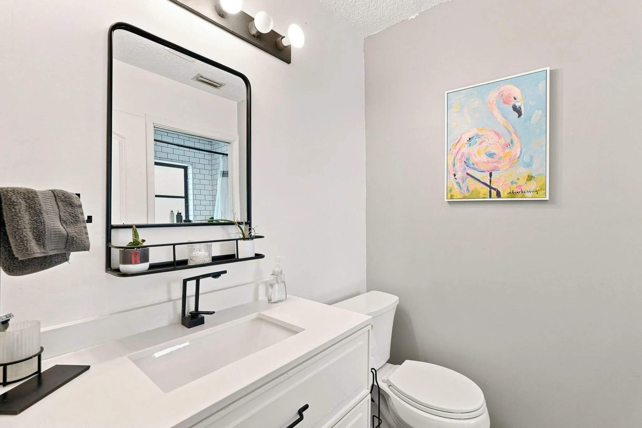 White vanity with a rectangular integrated sink, matte black faucet and white countertop