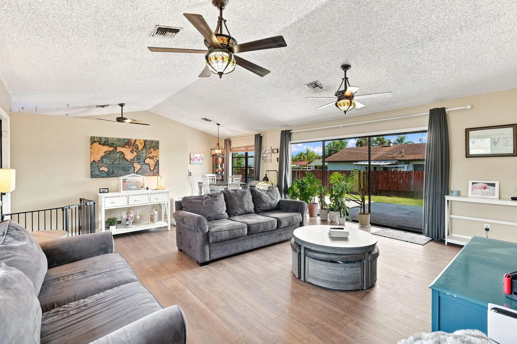 Vaulted ceilings with multiple ceiling fans, LVP flooring and large sliding glass doors