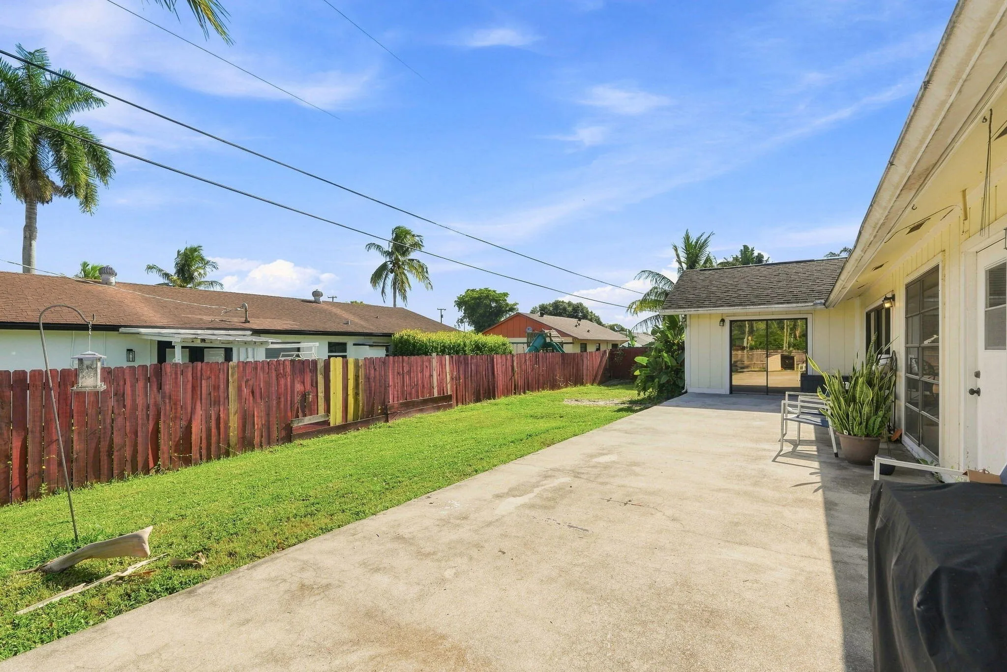 Expansive concrete patio with sliding glass door access to the interior