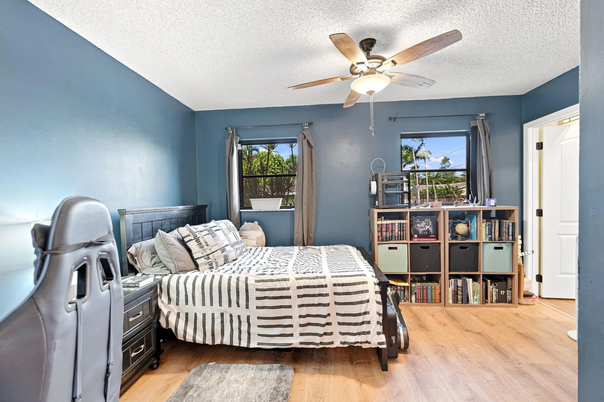 LVP flooring with dual windows and a ceiling fan with integrated lighting